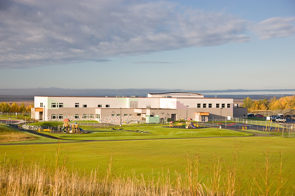 Multi-story school building and playground in distance
