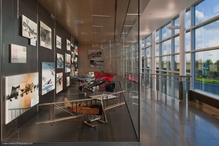Display case with model airplanes and old airplane photography