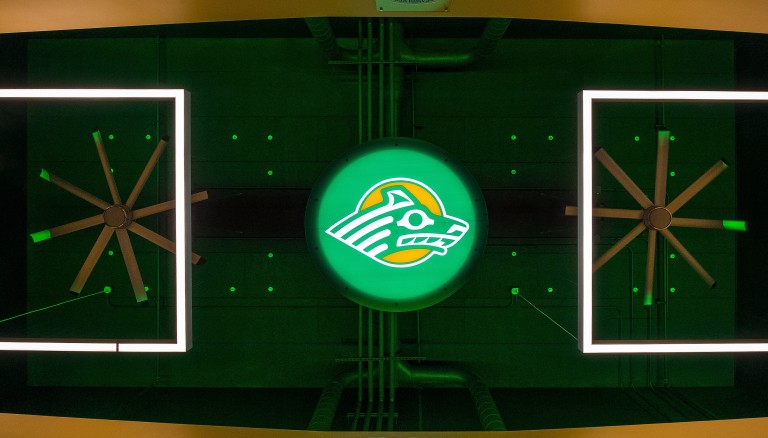 Decadent fans, lighting, and backlit University of Alaska Anchorage mascot logo above stadium