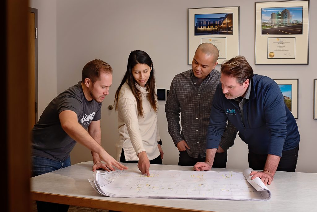 AMC employees looking at blueprints on table