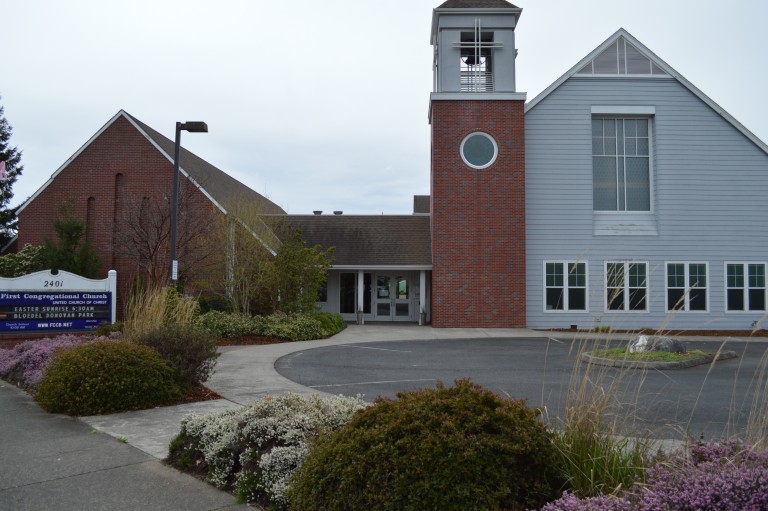 Exterior of red brick and wood panel church