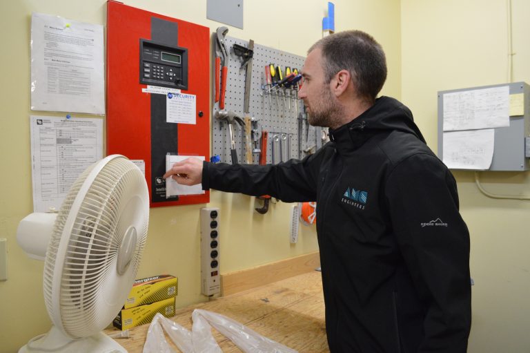 AMC employee looking at security panel in workroom