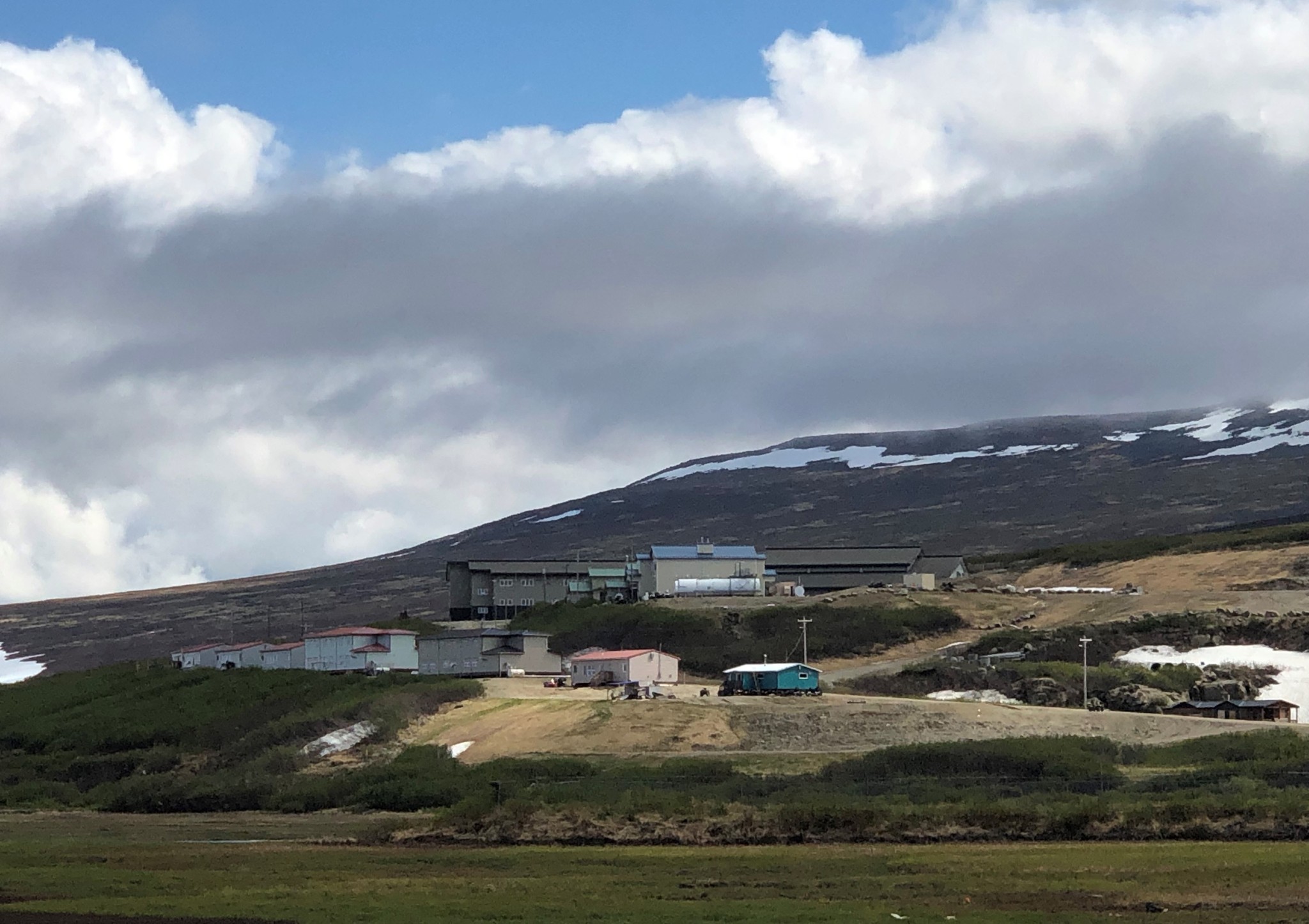 Buildings scattered in distance across snowy mountains
