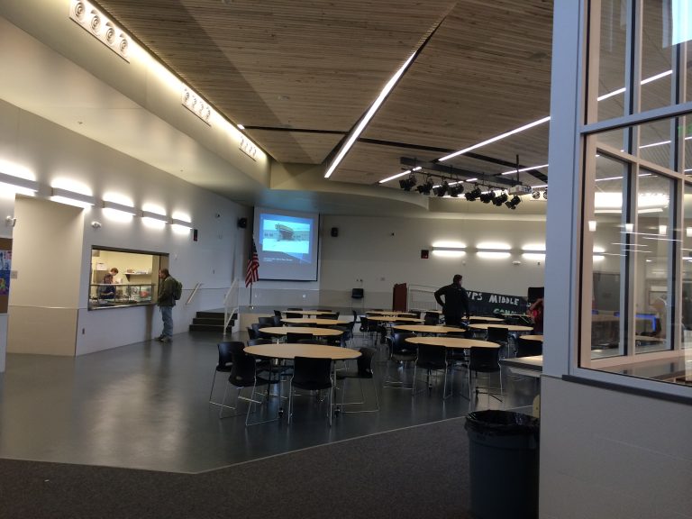 Decorative ceiling panels and stage lighting in cafeteria with small stage