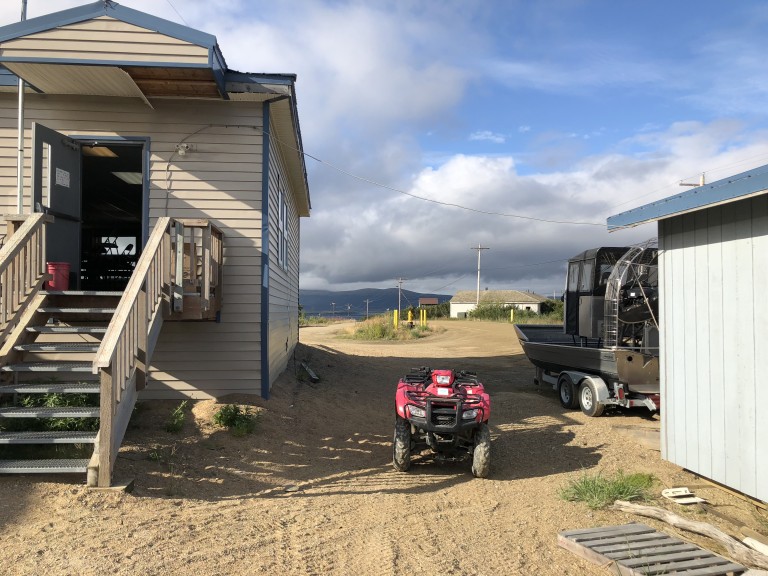 ATV parked outside wooden slab building
