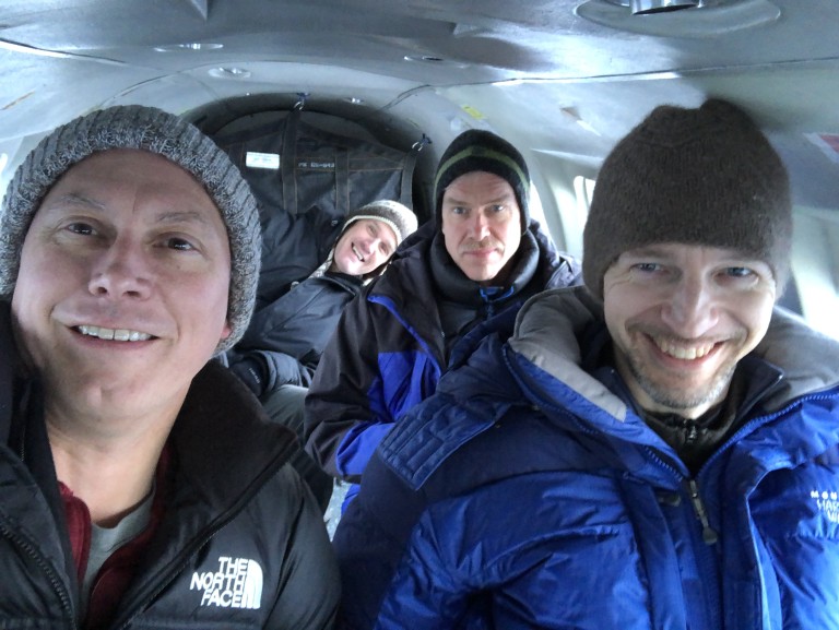 Group of men in heavy coats in small passenger plane