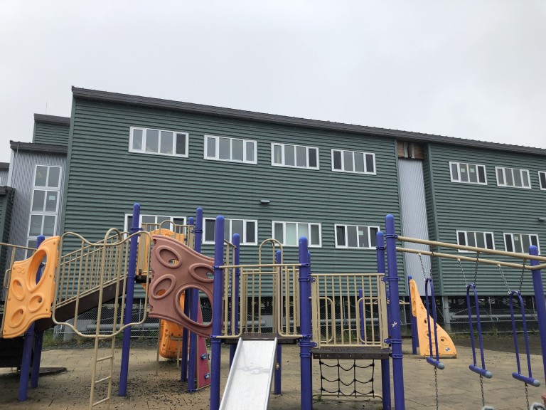 Playground outside green multistory building