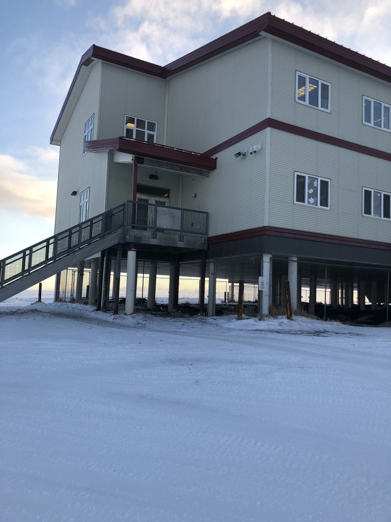 Multistory building elevated on stilts in snowy terrain