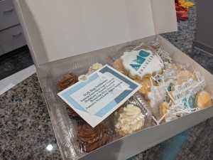 Gift box containing desserts and cookies with the AMC logo on them
