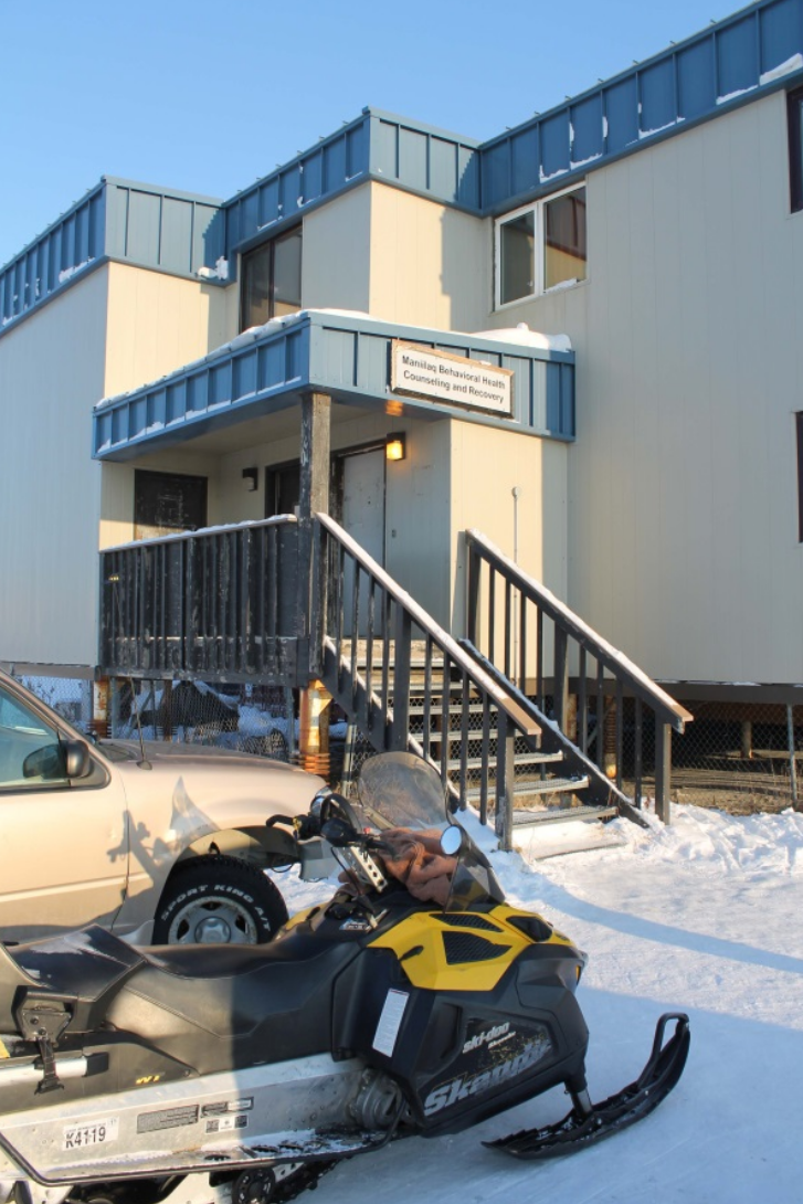 Cars and snowmobiles parked outside building